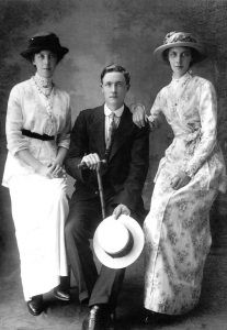 Two sisters and a brother posing for a photograph